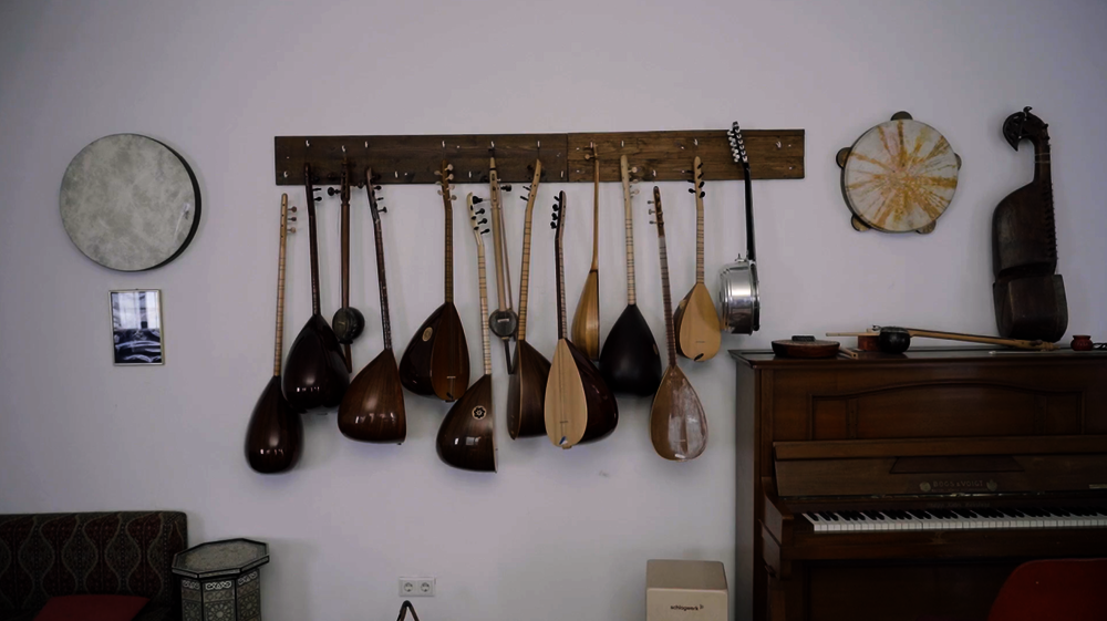 Bild aus der Filmdokumentation des Weiterkommen-Projekts der Orientalischen Musikakademie Mannheim. Dargestellt ist ein Hängeregal mit orientalischen Saiteninstrumenten.
