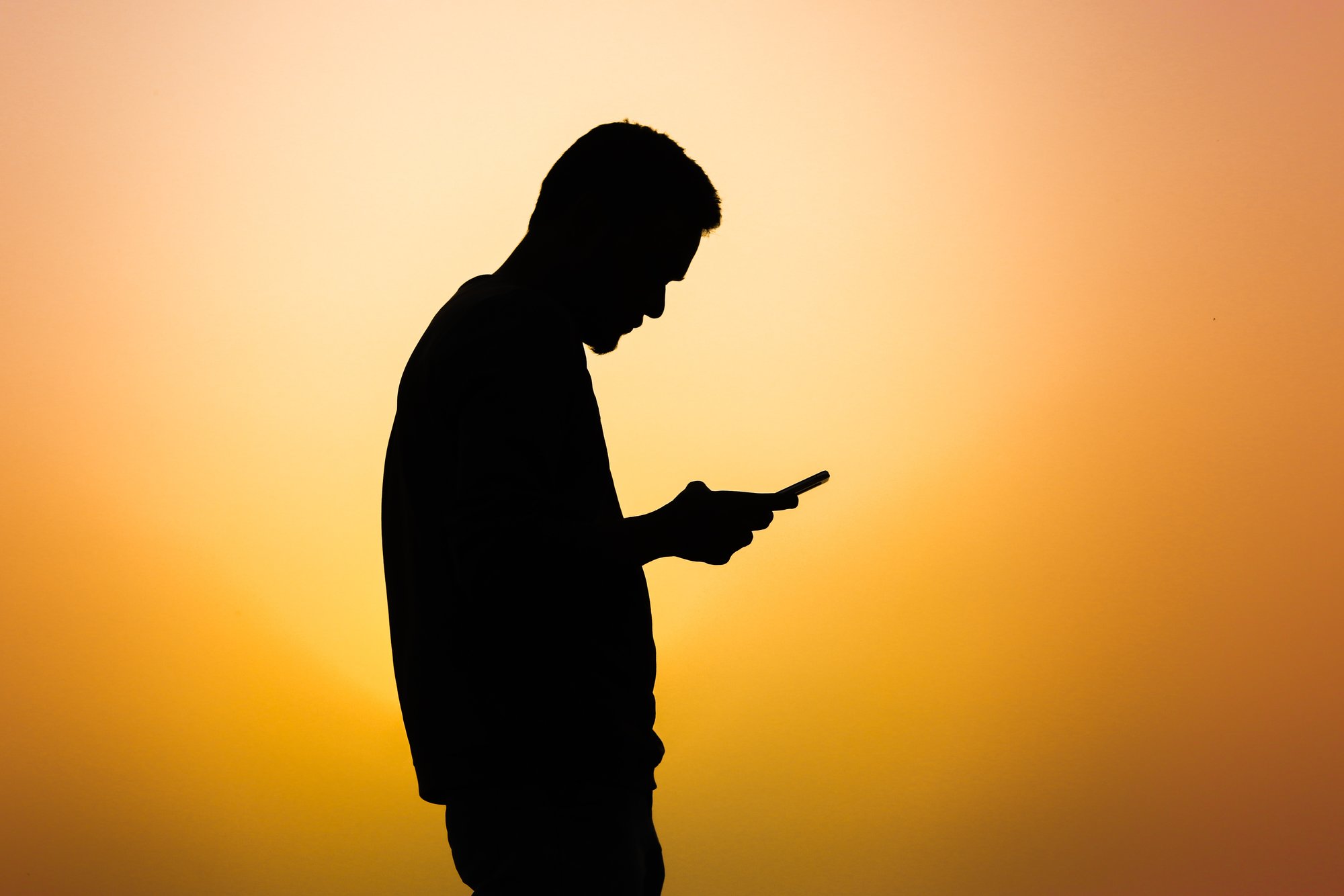 Die Silhouette eines Mannes, der ein Handy benutzt
Bild: Marwan Ahmed