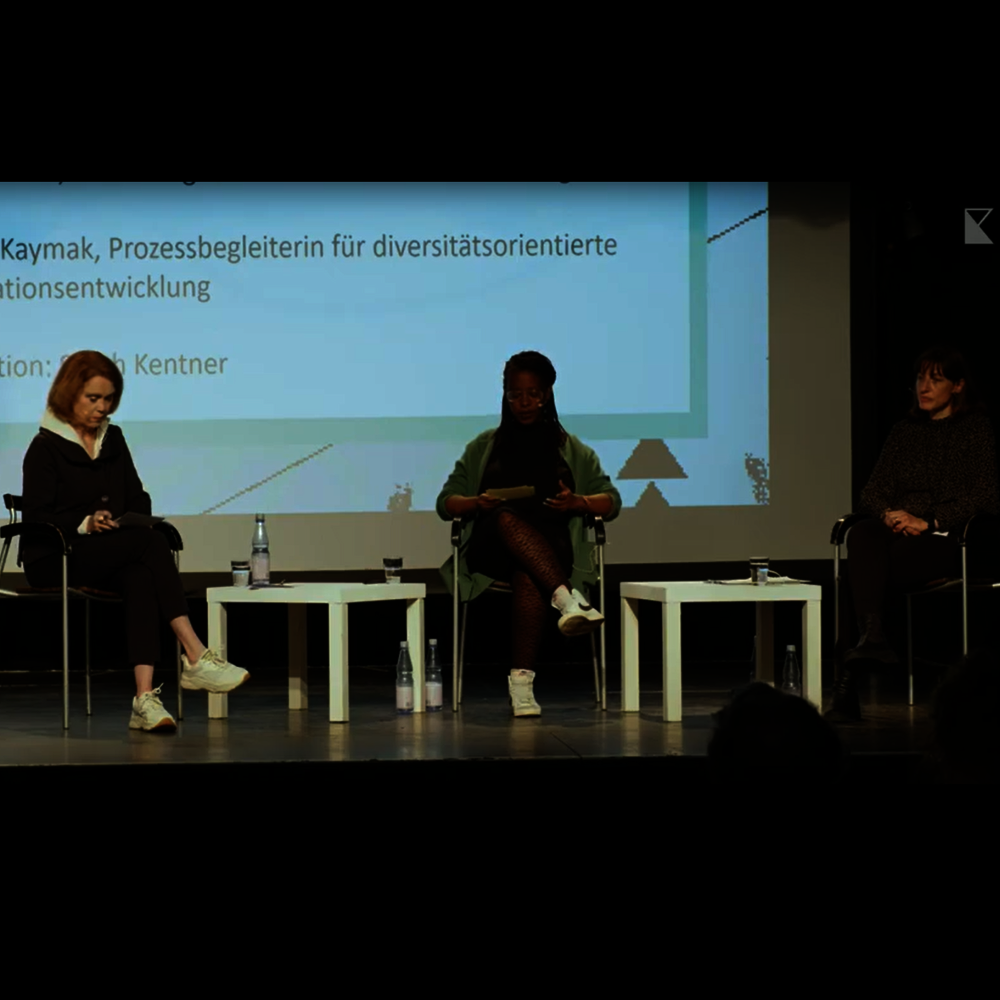 Foto einer Gesprächssituation auf der Bühne der Landesfachtagung "Kulturarbeit heute". Im Bild sind die Moderatorin Sarah Kentner und die Diskutantinnen Petra Olschowski und Handan Kaymak.