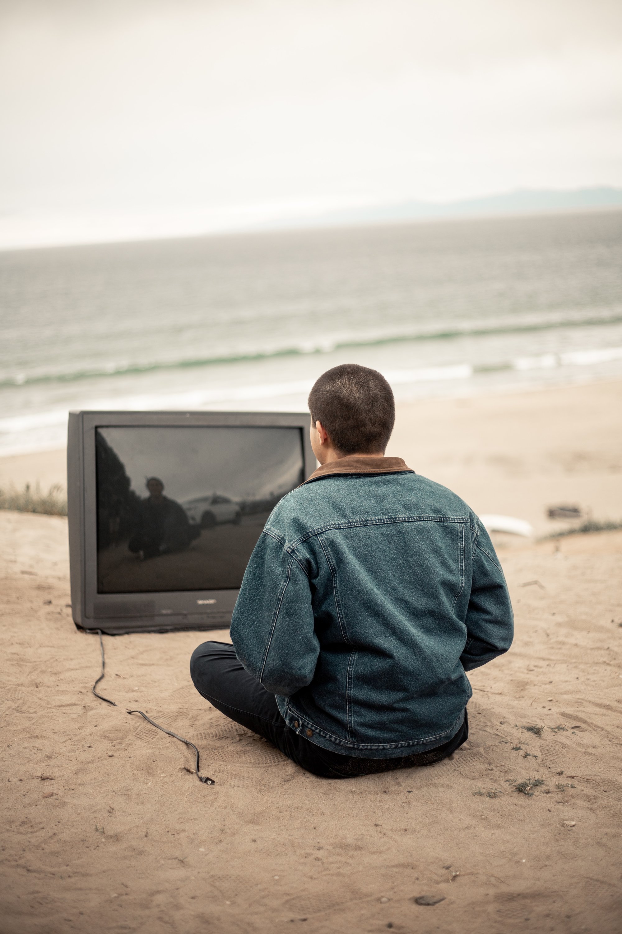 Mann sitzend vor Fernseher am Strand
Bild: Josh Kahen